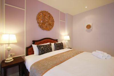 A Deluxe Room with carved gilt panel above the bed