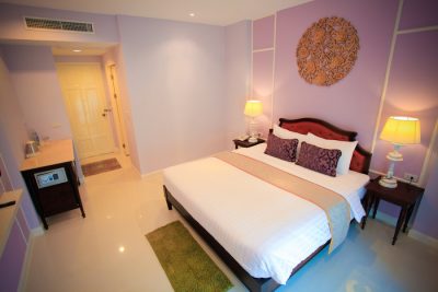 A Deluxe Room with carved gilt panel above the bed