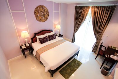 A Deluxe Room with carved gilt panel above the bed