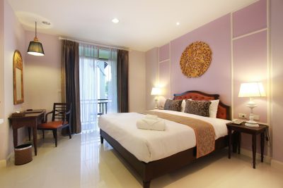 A Deluxe Room with carved gilt panel above the bed