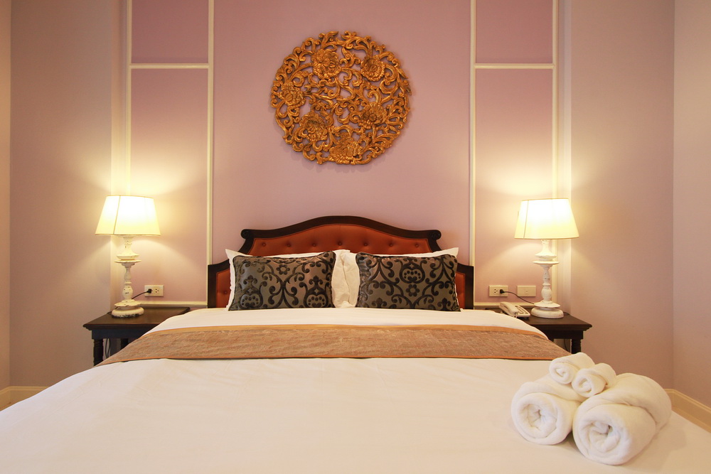 A Deluxe Room with carved gilt panel above the bed